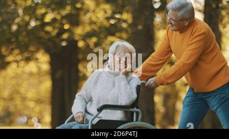 Vieux couple ayant un romantique jour d'automne dans la forêt. Un arbre enterre et souriant. Photo de haute qualité Banque D'Images