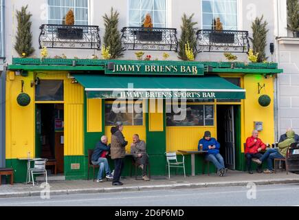 Killarney magasins bars peo boire et bavarder en plein air à des tables en plein air devant Jimmy Brien's Bar à Killarney, comté de Kerry, Irlande Banque D'Images