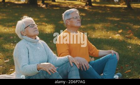 Concept de bien-être. Portrait d'un couple retraité senior heureux méditant dans le parc d'automne. Photo de haute qualité Banque D'Images