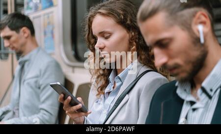 passagers utilisant un smartphone dans la voiture de métro . Banque D'Images