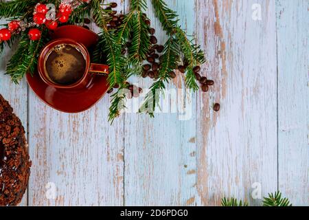 Tasse de café avec grains de café et branche de pin avec baies rouges. Concept de Noël ou de nouvel an. Banque D'Images