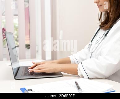 Vue rapprochée d'une femme médecin utilisant un ordinateur portable. Banque D'Images