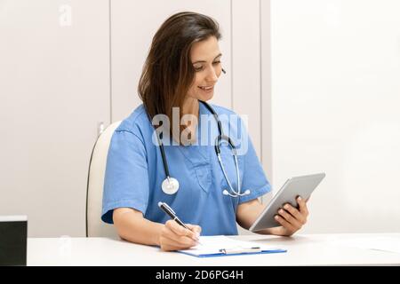 Médecin expliquant au patient via une tablette, application de santé mobile. Banque D'Images