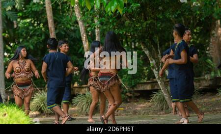 Tena, Napo / Equateur - octobre 10 2020: Groupe de jeunes dansant avec les costumes typiques des groupes ethniques de l'Amazone équatorienne dans un parc Banque D'Images