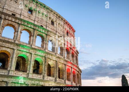 Le célèbre Colisée de Rome illuminé en drapeau tricolore italien au crépuscule Banque D'Images