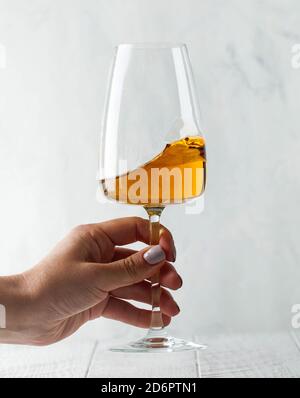 Un verre de vin d'orange dans les mains d'une fille. Copier l'espace. Banque D'Images
