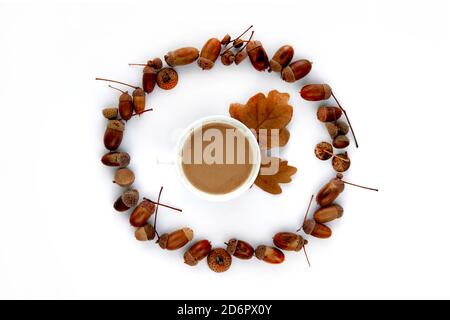 Composition d'automne. Cadre fait de feuilles séchées brunes, d'acornes et d'une tasse de café isolée sur fond blanc. Maquette automne, halloween Banque D'Images