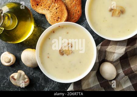 Concept de déjeuner savoureux avec bols de soupe aux champignons fond noir fumé Banque D'Images