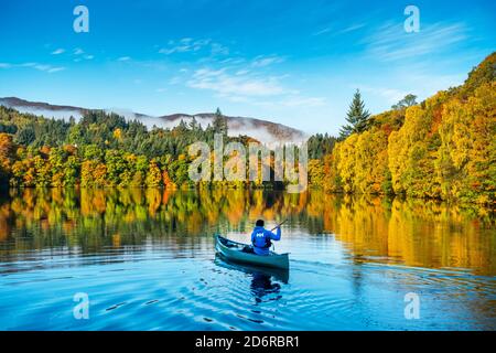 Kayakiste sur la rivière Tummel avec de superbes couleurs d'arbres automnales dans la ville de Pitlochry, Perthshire, Écosse, Royaume-Uni Banque D'Images