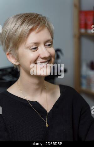 belle jeune femme blonde aux cheveux courts souriants Banque D'Images