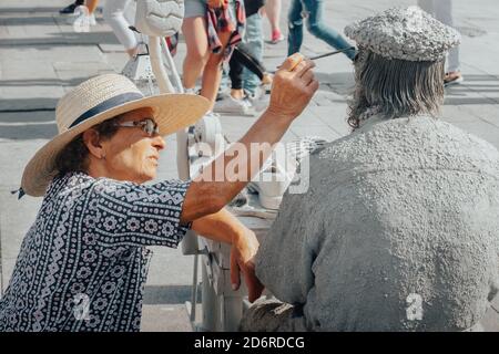 12.08.2019, Porto, Potugal. Vieilles femmes faisant une sculpture d'un cordonnier réparant des chaussures et des bottes. Artistes de rue, artistes de rue jouent dans la rue Banque D'Images