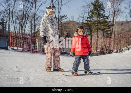 Père Fils enseigne la planche. Activités pour les enfants en hiver. Pour l'hiver. Vie Banque D'Images