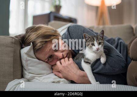 Femme à l'intérieur sur le canapé à la maison se sentant stressée, concept de santé mentale. Banque D'Images