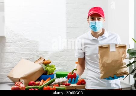 Homme avec des produits frais à la table à l'intérieur, gros plan. Service de livraison de nourriture Banque D'Images