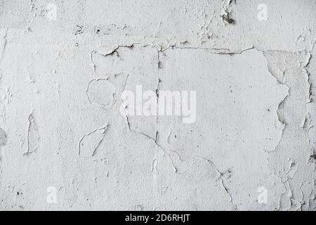 Grafez la texture blanche du mur abîmé avec la peinture qui s'écaille de la surface, le motif de la façade usé comme arrière-plan Banque D'Images