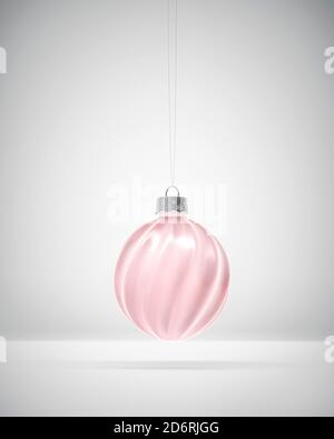 Boule de Noël à côtes, brillante et rose, suspendue sur fond blanc. Lumière diffuse. Décoration de Noël, concept d'atmosphère festive. Banque D'Images