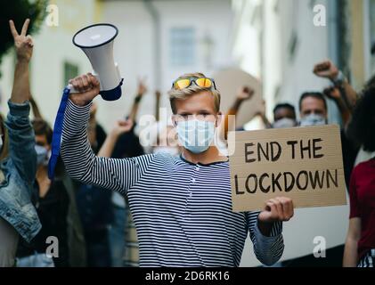 Personnes avec des placards et des affiches sur la démonstration publique, fin du confinement et le concept de coronavirus. Banque D'Images