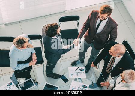 vue de dessus. les hommes d'affaires se secouent la main dans la salle de réunion. Banque D'Images