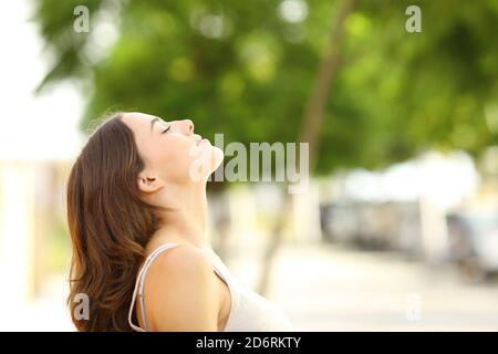 Profil d'une belle femme respirant de l'air frais assis un parc Banque D'Images