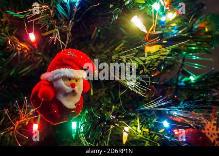 Arbre de Noël avec jouet suspendu du Père noël et guirlande lumineuse. Carte du nouvel an, sélection Banque D'Images