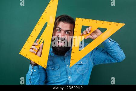 homme heureux avec la taille mesurée sur l'outil de mathématiques de règle de triangle, étude d'école. Banque D'Images