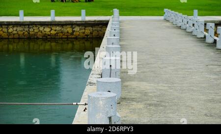 Protection des piétons en béton près d'un lac dans un parc. Petites poteaux blancs en béton sur une passerelle. Banque D'Images