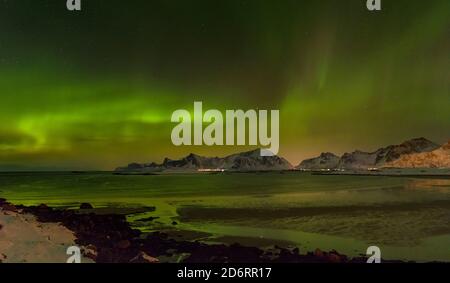 Lumières du Nord sur la plage d'Ytresand près du village de Fredvang, vue sur l'île Flakstadoya. L'île de Moseknesoya, les îles Lofoten dans le nord de No Banque D'Images