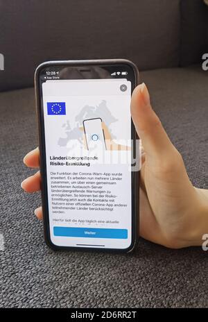 19 octobre 2020, Berlin: Une femme possède un iPhone avec la version actuelle de l'application d'avertissement Corona, enregistrée lundi (19.10.2020) l'application Corona-WARN du gouvernement fédéral allemand peut désormais également avertir d'une rencontre potentiellement dangereuse avec des personnes infectées par le corona à travers les frontières. Comme annoncé, la mise à jour de la version 1.5 est apparue dans les App Stores de Google et Apple lundi après-midi. Cela signifie que les contacts avec les utilisateurs des applications officielles de Corona d'autres pays peuvent désormais être identifiés lors de l'évaluation des risques. Photo: Christoph Dernbach/dpa Banque D'Images