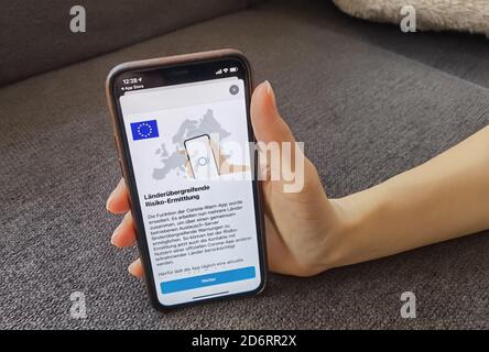 19 octobre 2020, Berlin: Une femme a un iPhone avec la dernière version de l'application d'avertissement Corona. La Corona-WARN-App du gouvernement fédéral peut maintenant aussi avertir d'une rencontre potentiellement dangereuse avec des personnes infectées par le corona au-delà des frontières. Comme annoncé, la mise à jour de la version 1.5 est apparue dans les App Stores de Google et Apple lundi après-midi. Cela signifie que les contacts avec les utilisateurs des applications officielles de Corona d'autres pays peuvent maintenant être identifiés au cours de l'évaluation des risques. Photo: Christoph Dernbach/dpa Banque D'Images