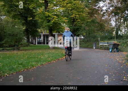 19 octobre 2020, Berlin: Une femme passe à vélo dans le Kleiner Tiergarten. Un tchétchène a été abattu à cet endroit le 23 août 2019. Un suspect a été arrêté près de la scène du crime. Le meurtre a provoqué une sensation internationale. À la fin de 2019, le procureur général a repris l'affaire. En juin 2020, le procureur général a porté des accusations contre un citoyen russe, qualifiant le crime de meurtre par contrat et faisant référence au gouvernement de la Fédération de Russie comme le cerveau derrière le meurtre par contrat. Le procès du meurtrier présumé a été en cours à la Cour supérieure de Berlin sinc Banque D'Images