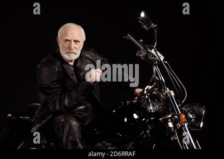 Portrait de son il gentil vieux sérieux gris-cheveux dude hipster punk-bunker assis sur un chopper passant du temps loisir passe-temps durée du voyage Banque D'Images