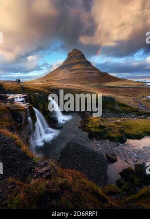 Paysage spectaculaire de sommet de montagne et cascade sous coucher de soleil nuageux Ciel en Islande Banque D'Images