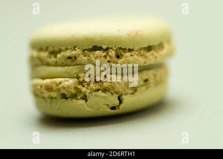 Macaron coloré et savoureux sur fond vert. Banque D'Images