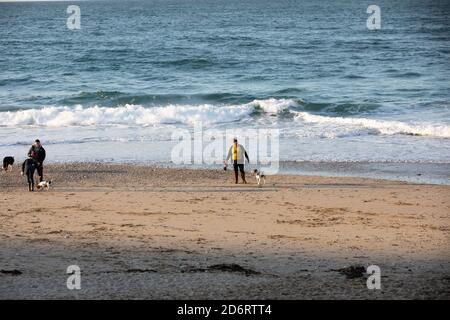 Personnes marchant en fin d'après-midi sur la plage de Portreath, Cornwall, Royaume-Uni Banque D'Images