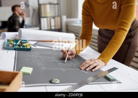 Photo rognée d'une femme architecte méconnue qui dessine des plans et des plans tout en travaillant au bureau, dans l'espace de travail Banque D'Images