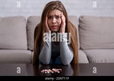 Crise émotionnelle et suicide. Jeune femme avec des pilules ayant des troubles psychologiques et la planification de se tuer Banque D'Images