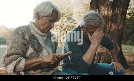 Les personnes âgées craignaient un couple assis sur le banc dans le désespoir. Femme comptant les dernières pièces. Photo de haute qualité Banque D'Images