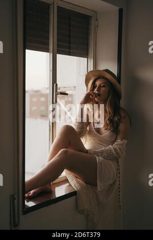 Crop Muslim femelle dans hijab écrit dans le journal tout en étant assis sur la rue de la ville et vue loin Banque D'Images