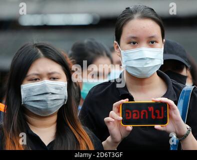 Un étudiant portant un masque facial tient un smartphone affichant un panneau devant l'université de Kasetsart pendant la manifestation.des manifestants anti-gouvernementaux assistent à une grande manifestation demandant la démission du Premier ministre thaïlandais et la réforme de la monarchie suite à un « état d'urgence » déclaré par le Premier ministre Prayut Chan-o-cha. Banque D'Images