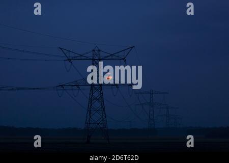 Lune de sang derrière la tour d'électricité à l'heure bleue Banque D'Images