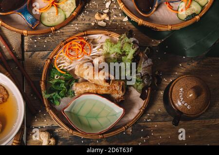 Grand angle de petits pains frits servis sur l'assiette avec Laitue fraîche et pousses de haricots sur table en bois en vietnamien restaurant Banque D'Images