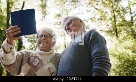 Couple d'âge mûr amoureux prenant selfie dans la forêt le jour de l'automne. Photo de haute qualité Banque D'Images