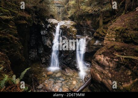 Belle vue sur l'eau en cascade dans un canyon entouré par nature verte Banque D'Images