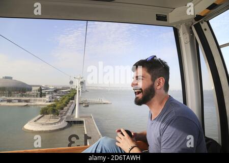 Un homme caucasien barbu en train de profiter de son RID dans un câble Ascenseur pour voiture au-dessus de Lisbonne au Portugal Banque D'Images