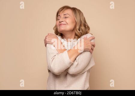 Femme caucasienne senior se embrassant heureux et positif, souriant confiant Banque D'Images