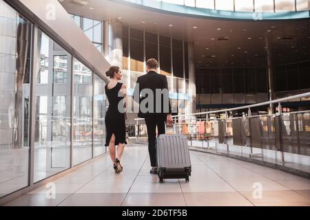 Femme et homme transportant leur valise à l'aéroport Banque D'Images