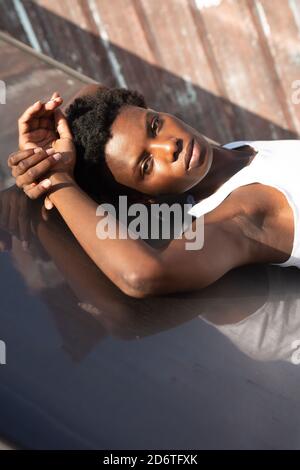 Une femme d'âge moyen positive prend son autoportrait tout en étant assise à table avec verre d'eau dans la cuisine moderne à la maison Banque D'Images