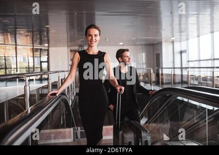 Femme souriante arrivant à l'aéroport ou en voyage d'affaires Banque D'Images