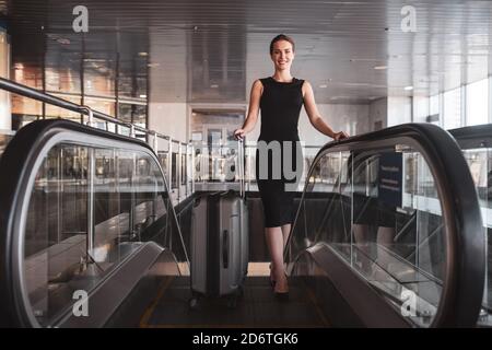 Femme transportant ses bagages à travers l'aéroport Banque D'Images