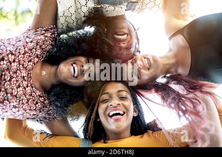 De dessous de groupe de femmes gaies multiraciales debout ensemble et de regarder l'appareil photo Banque D'Images